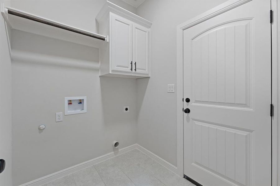 Laundry room featuring electric dryer hookup, hookup for a washing machine, light tile patterned floors, cabinet space, and gas dryer hookup Laundry room featuring electric dryer hookup, hookup for a washing machine, light tile patterned floors, cabinet space, and gas dryer hookup