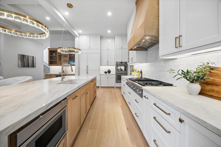 This chef’s kitchen pairs custom cabinetry and natural stone surfaces with an undercounter microwave and 48-inch Thermador cooktop for a clean, highly functional workspace. This chef’s kitchen pairs custom cabinetry and natural stone surfaces with an undercounter microwave and 48-inch Thermador cooktop for a clean, highly functional workspace.