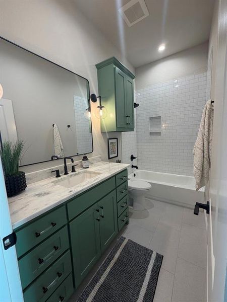 Bathroom with vanity, shower / bath combination, and light tile patterned flooring