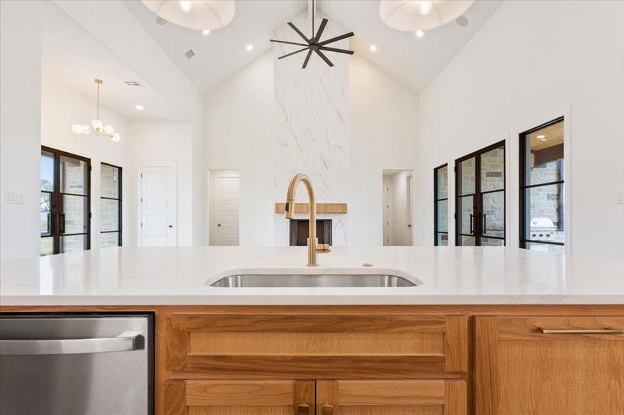 Kitchen with dishwasher, high vaulted ceiling, light stone counters, and recessed lighting