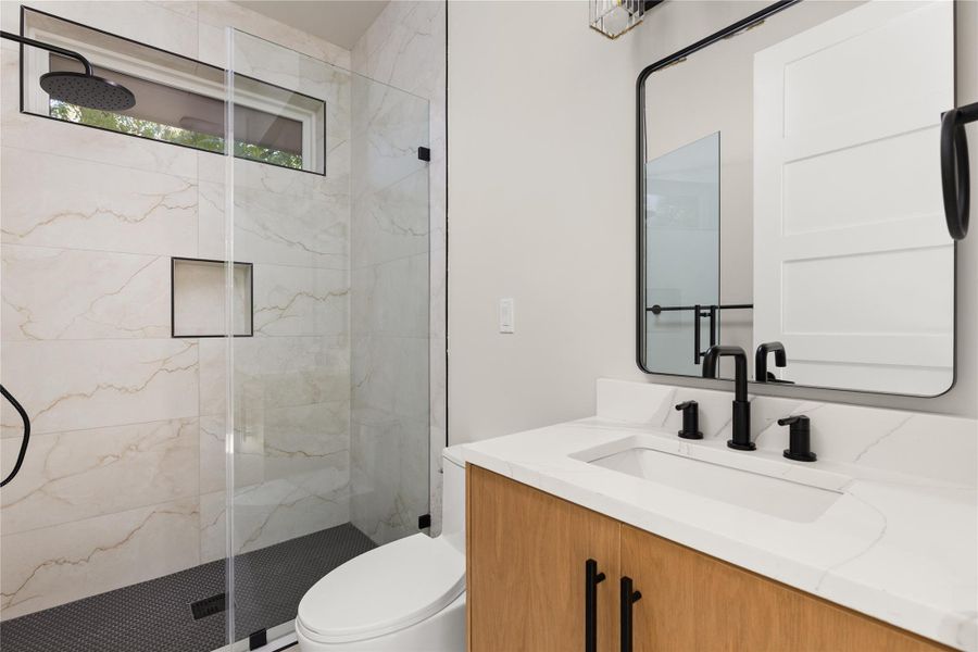 Elegant design elements define this contemporary bathroom with a glass-enclosed walk-in shower.