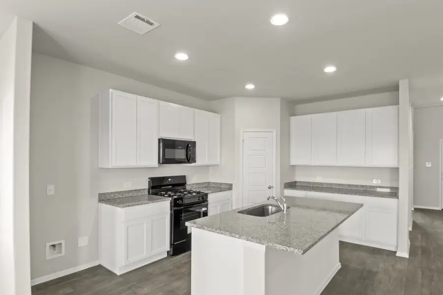 Image of a kitchen with white cabinets, granite countertops, black appliances, a corner pantry Image of a kitchen with white cabinets, granite countertops, black appliances, a corner pantry
