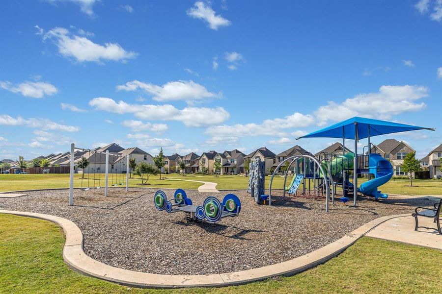 Communal playground with a yard and a residential view