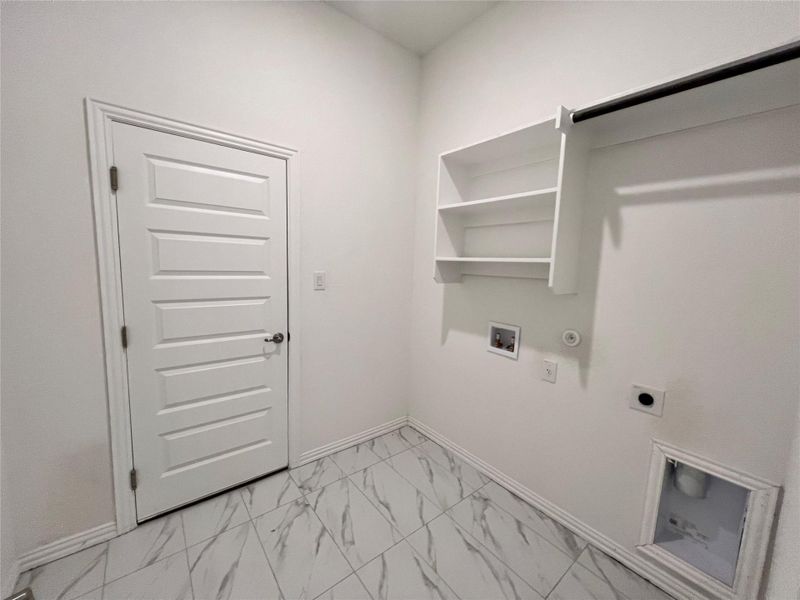 Washroom with electric dryer hookup, light marble finish flooring, hookup for a washing machine, and hookup for a gas dryer Washroom with electric dryer hookup, light marble finish flooring, hookup for a washing machine, and hookup for a gas dryer