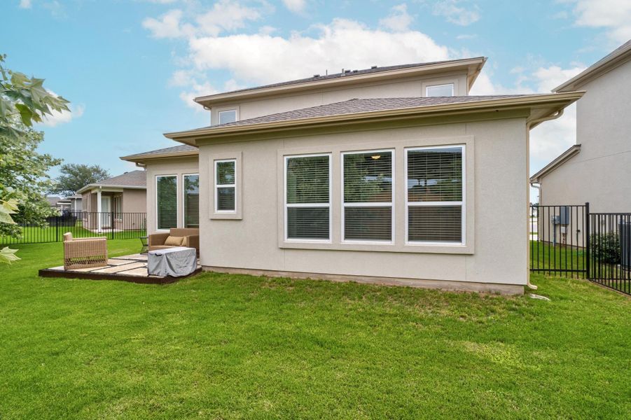 Rear view of property with a fenced backyard, stucco siding, and a yard Rear view of property with a fenced backyard, stucco siding, and a yard