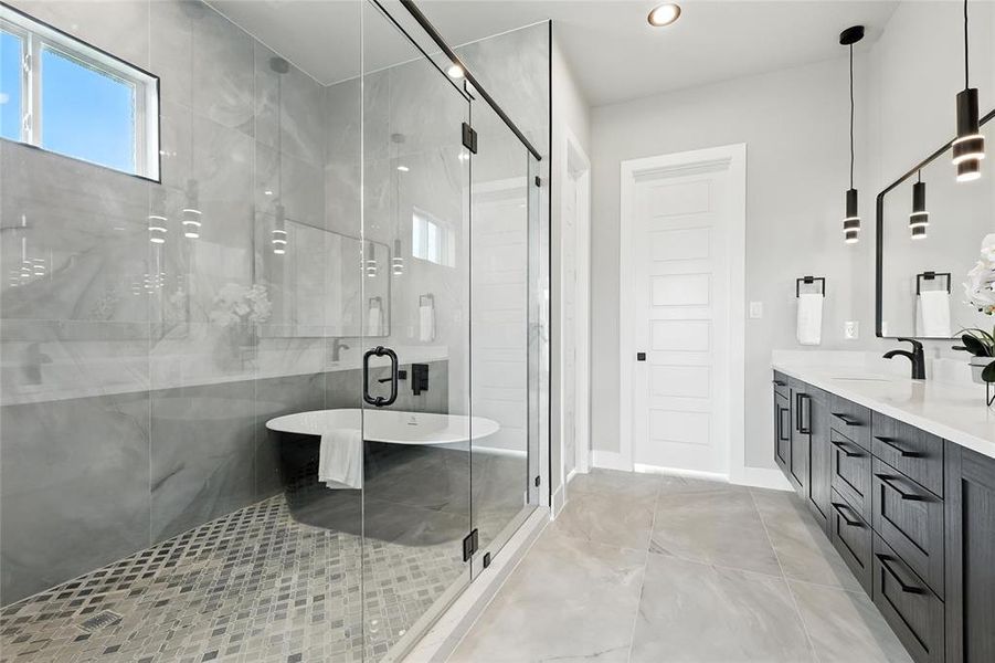 Full bathroom featuring double vanity, a freestanding bath, a shower stall, and recessed lighting