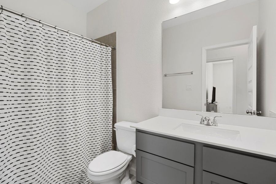 Well-appointed guest bathroom with a modern vanity and clean tile work. Well-appointed guest bathroom with a modern vanity and clean tile work.