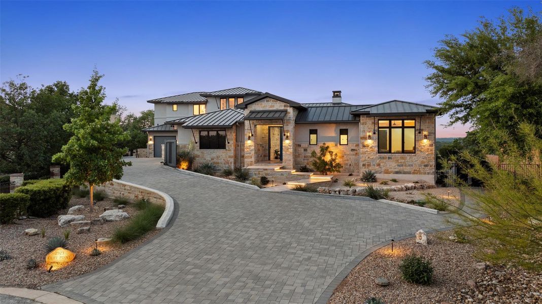 Contemporary stone and stucco exterior with multiple gables and a metal roof