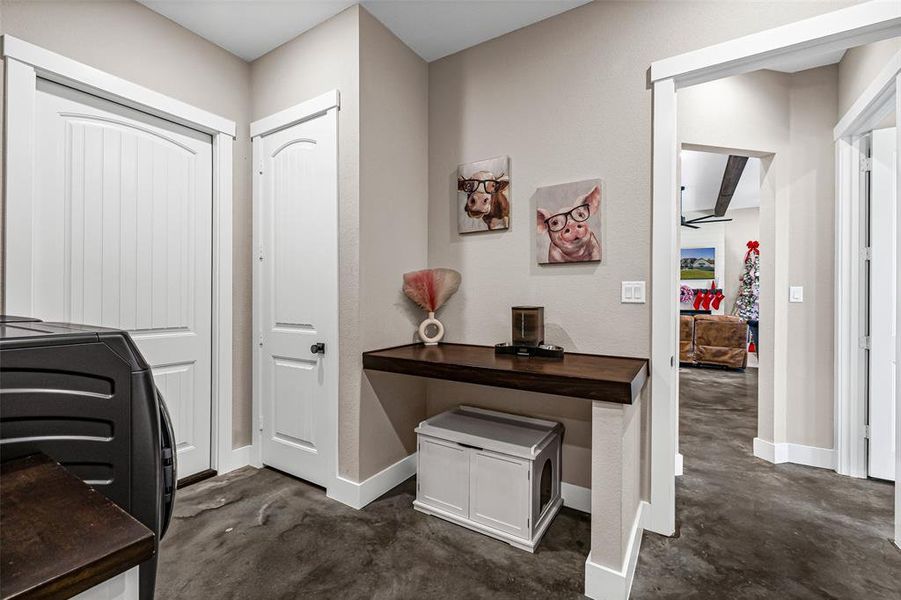 Office area featuring concrete flooring and washer / dryer Office area featuring concrete flooring and washer / dryer