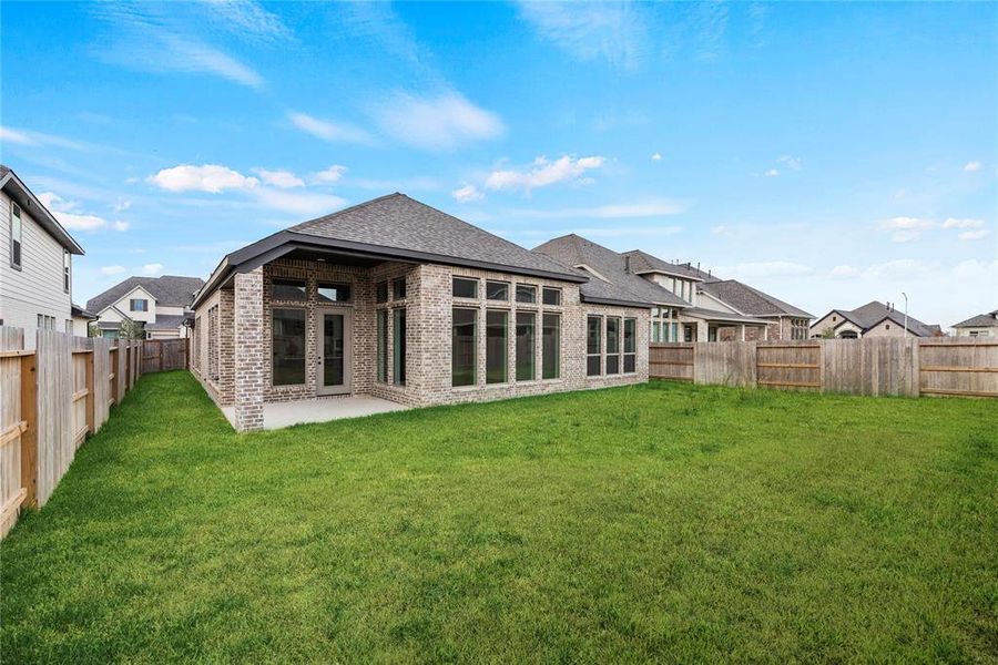 Private backyard with a covered patio. Grass has been enhanced in photo.