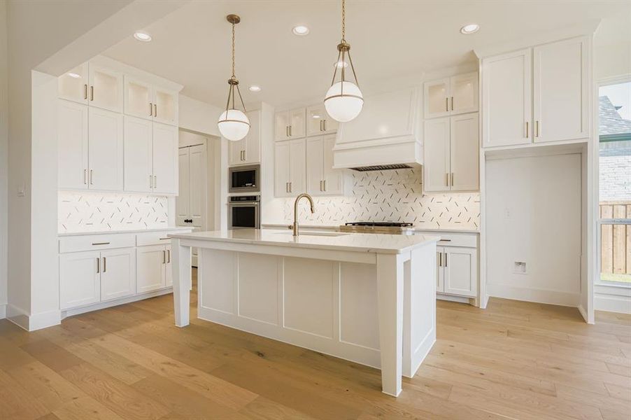 Kitchen with glass insert cabinets, recessed lighting, decorative backsplash, white cabinetry, and light wood finished floors