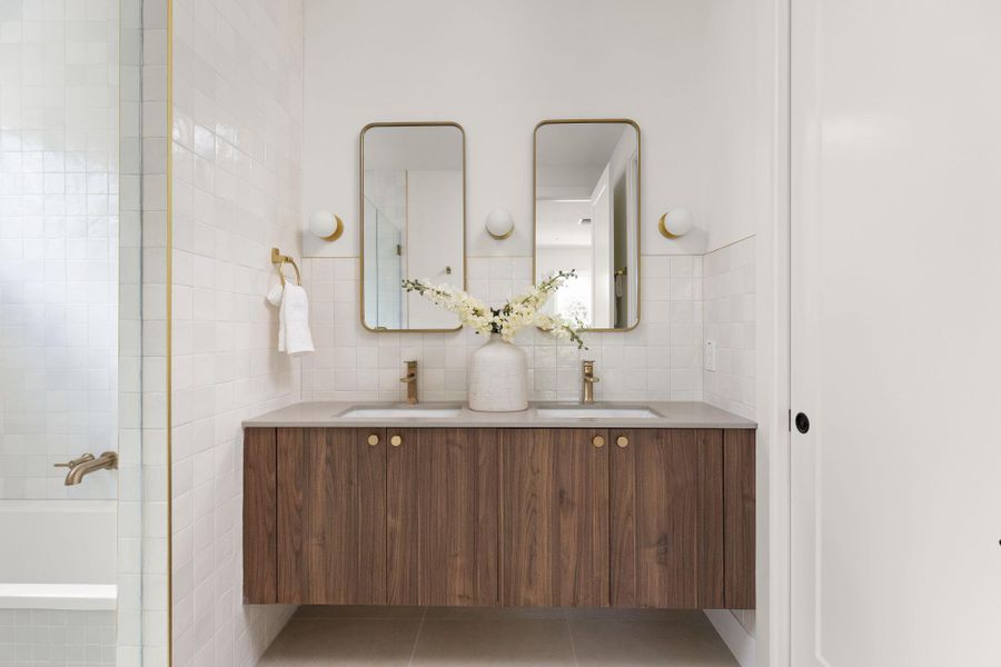 A well-appointed bathroom features a double vanity and sleek modern fixtures. A well-appointed bathroom features a double vanity and sleek modern fixtures.