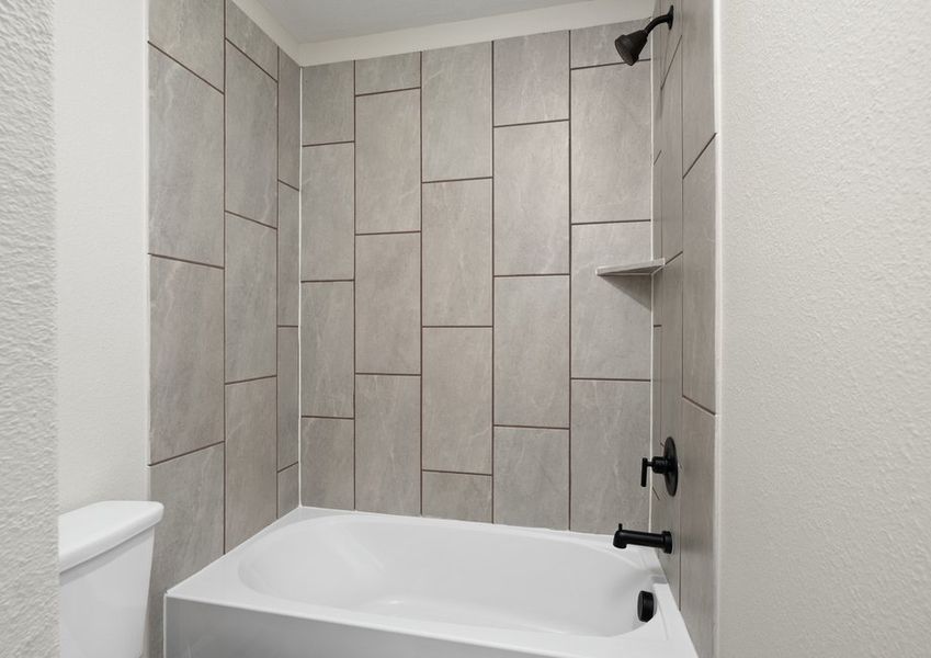 The secondary bathroom has a tiled shower-tub combo.