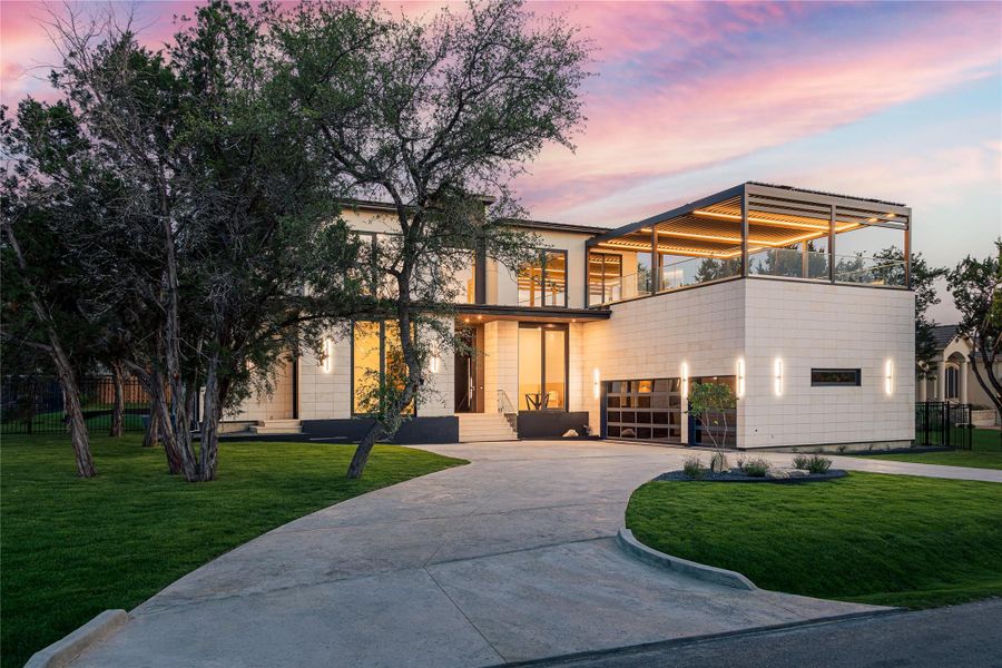 Dramatic modern architecture with a private balcony, showcasing sleek lines and elegant stone construction against a vibrant sunset.