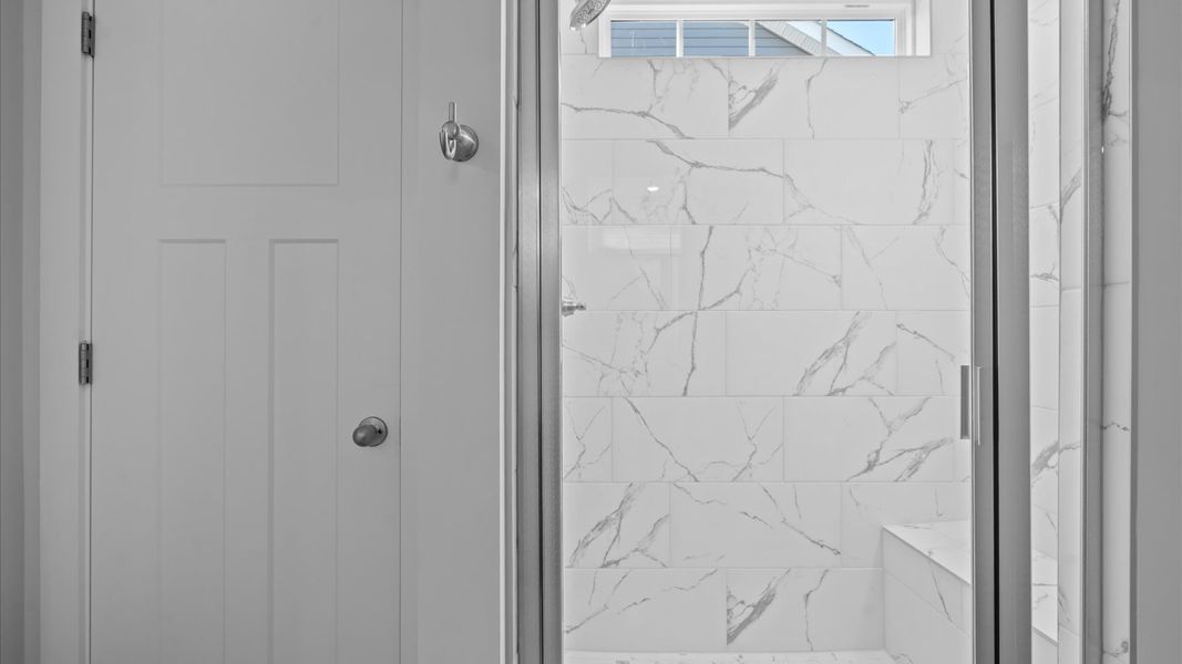 Memorable mornings begin in this elegant primary bathroom with walk-in shower and double vanity