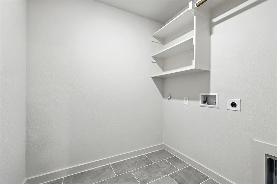 Washroom with hookup for a washing machine, electric dryer hookup, tile patterned floors, and hookup for a gas dryer Washroom with hookup for a washing machine, electric dryer hookup, tile patterned floors, and hookup for a gas dryer