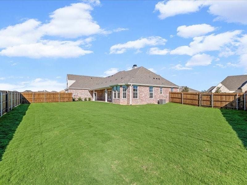 Rear view of property featuring a fenced backyard, a patio, brick siding, and a chimney
