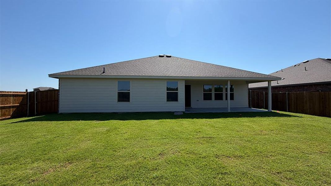 Expansive green lawn with a full wooden fence Expansive green lawn with a full wooden fence