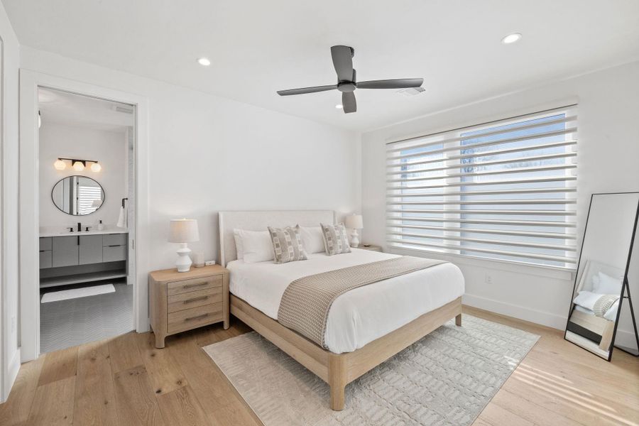 Bedroom featuring ceiling fan, light wood-style flooring, recessed lighting, and ensuite bath