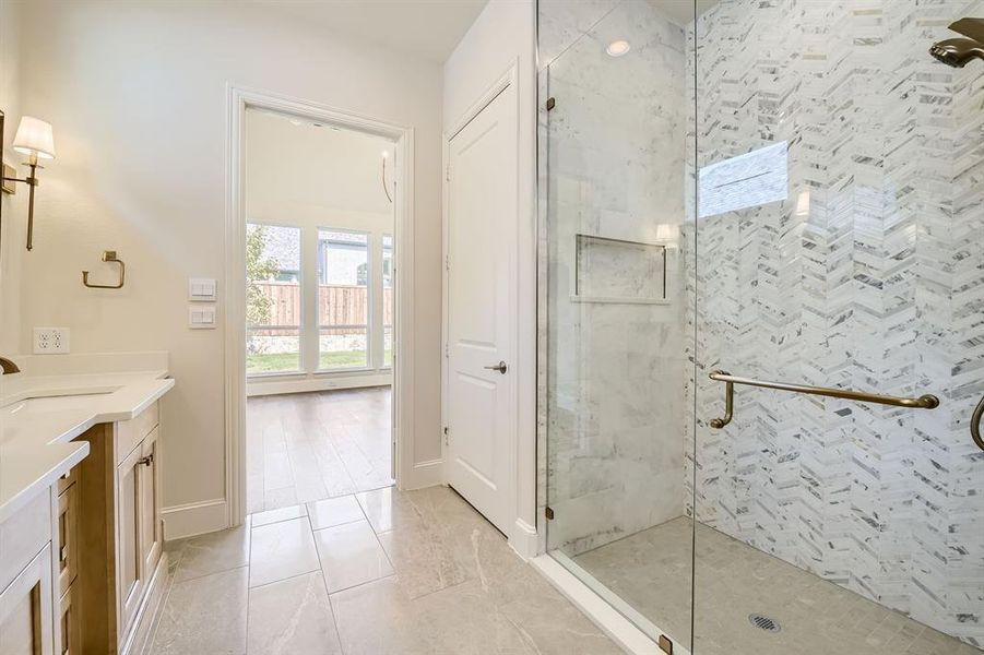 Primary bathroom with oversized shower with frameless glass enclosure