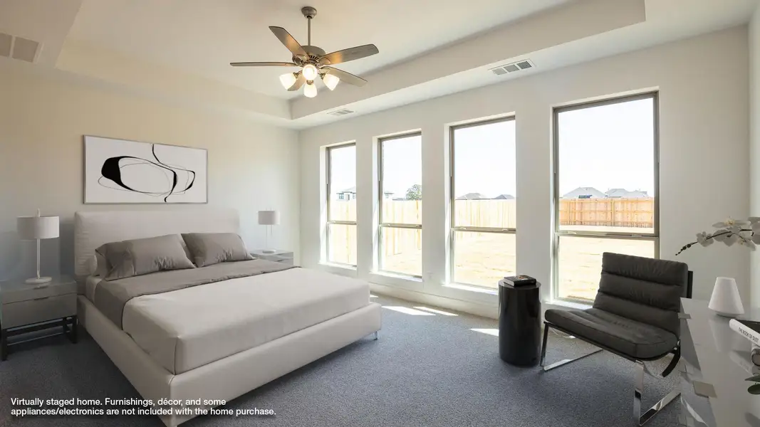 Bedroom featuring a tray ceiling, carpet floors, and a ceiling fan Bedroom featuring a tray ceiling, carpet floors, and a ceiling fan