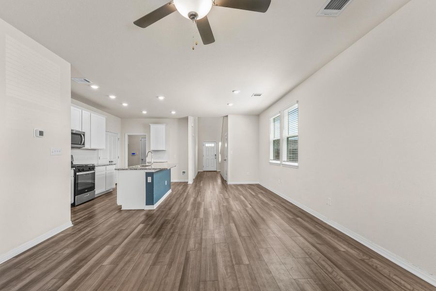 Kitchen with white cabinets, open floor plan, dark wood-style floors, a kitchen island with sink, and recessed lighting Kitchen with white cabinets, open floor plan, dark wood-style floors, a kitchen island with sink, and recessed lighting