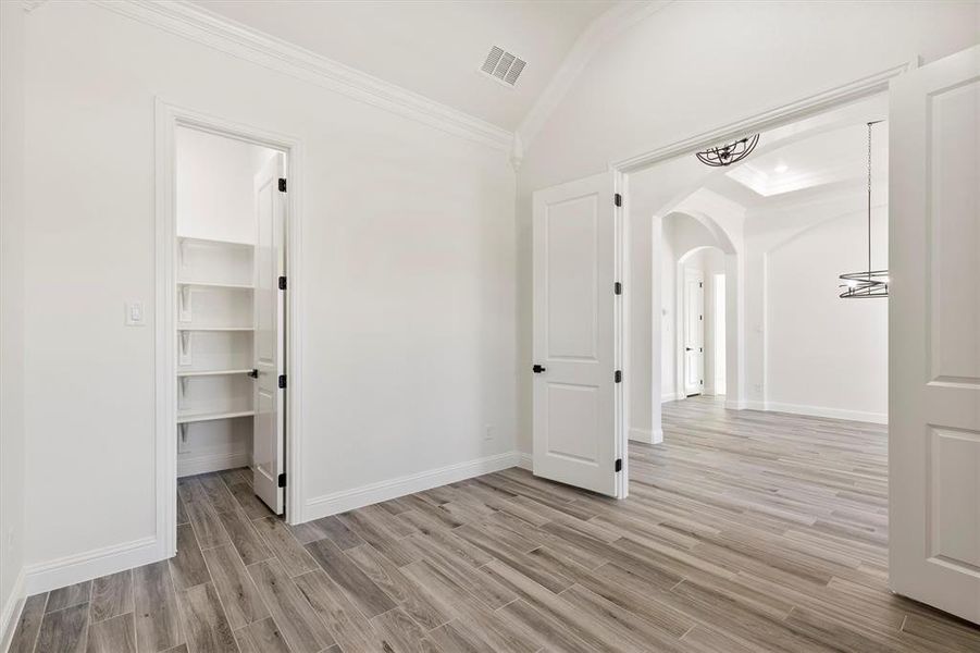 Office with a walk in closet, crown molding