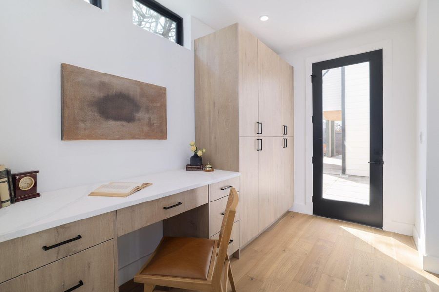 Doorway to outside featuring built in desk, wood finished floors, plenty of natural light, and recessed lighting