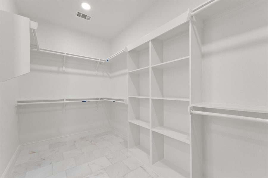 Walk in closet with light marble finish floors
