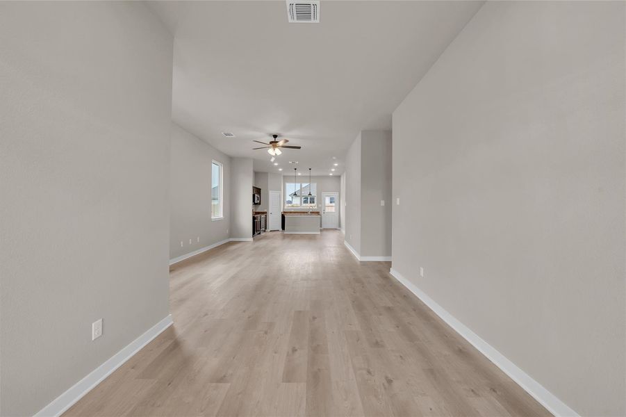 Unfurnished living room with light wood-style floors and ceiling fan