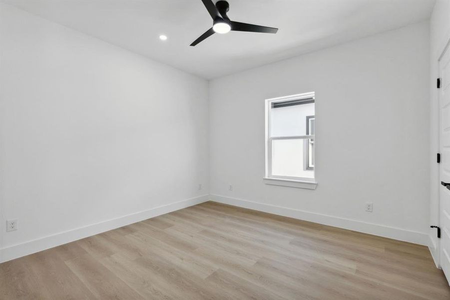 Spare room with light wood-type flooring and ceiling fan