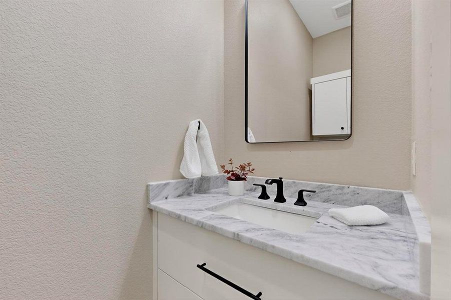 Bathroom featuring vanity and a textured wall