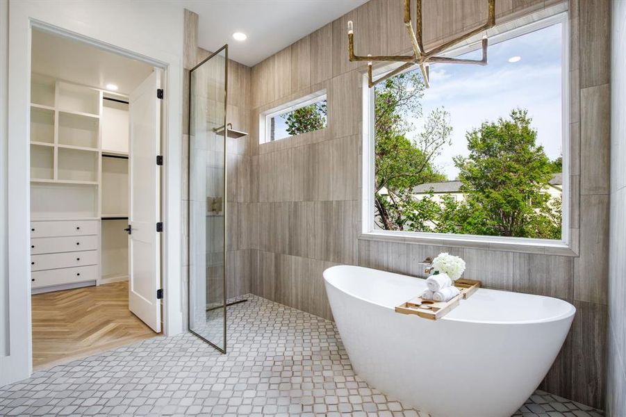 Freestanding soaking tub with a large picture window, a walk-in shower with a glass enclosure, and modern wall-mounted light fixture Freestanding soaking tub with a large picture window, a walk-in shower with a glass enclosure, and modern wall-mounted light fixture