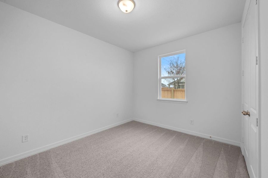 Your secondary bedroom features plush carpet, fresh paint, closet, and a large window that lets in plenty of natural lighting.