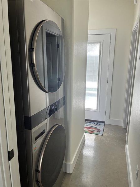 Laundry area with baseboards and stacked washer / drying machine