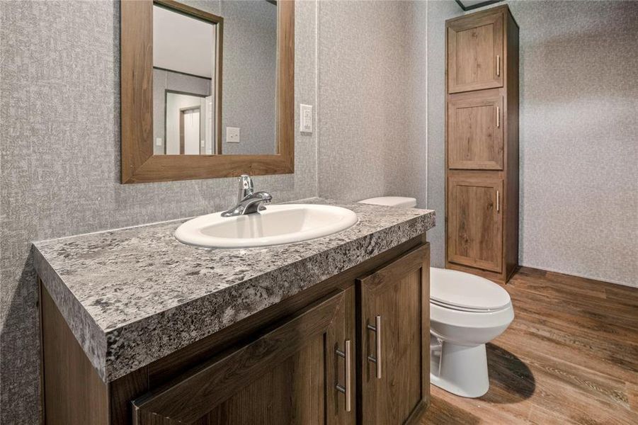 Half bath featuring vanity and wood finished floors