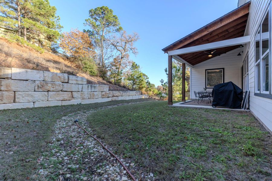 View of grassy yard featuring a patio area and a ceiling fan