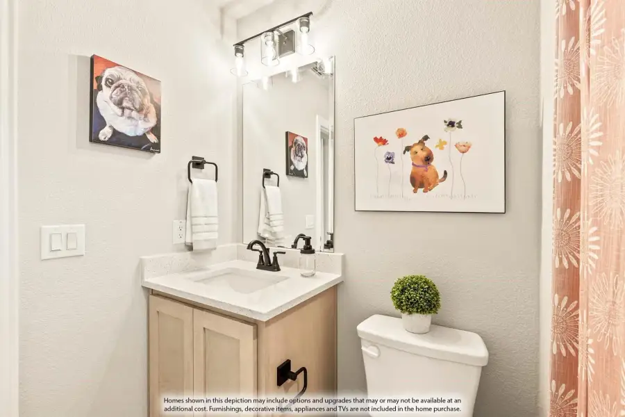 Bathroom with light wood vanity, white quartz countertop, black fixtures, large mirror, and toilet