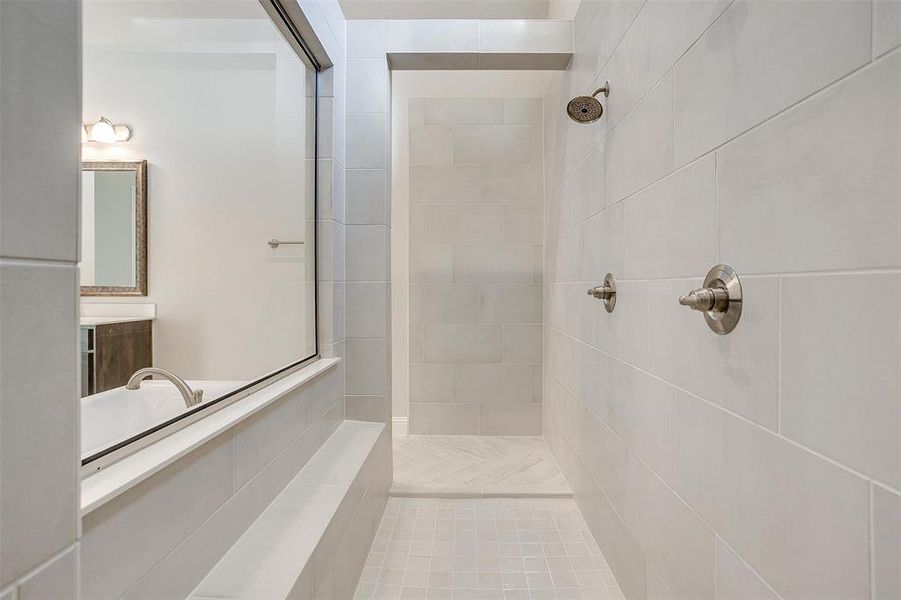 Bathroom featuring vanity, a tile shower, and tile patterned floors