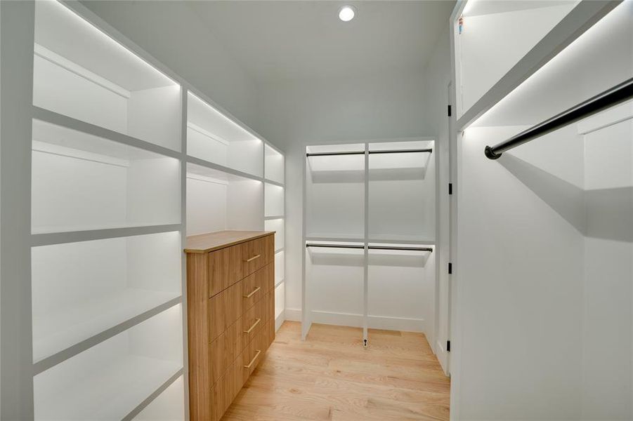 Walk in closet with light wood-type flooring