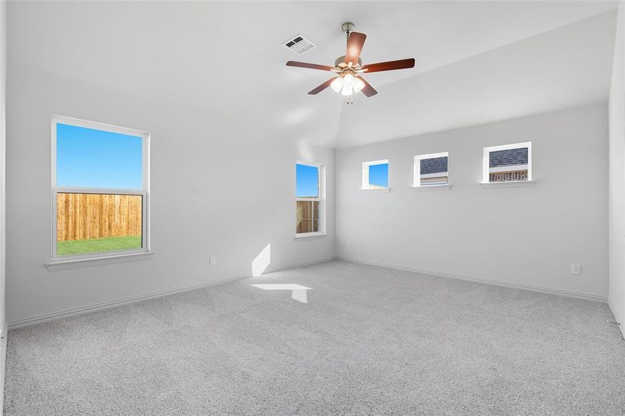Empty room featuring light colored carpet, healthy amount of natural light, and a ceiling fan Empty room featuring light colored carpet, healthy amount of natural light, and a ceiling fan