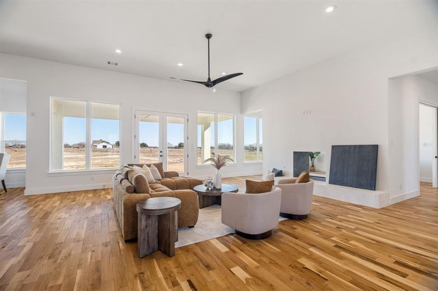 Living room featuring ceiling fan, light wood-type flooring, and french doors