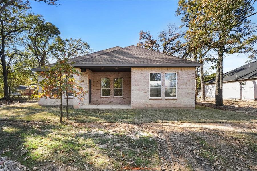 Back of property with a yard and a patio