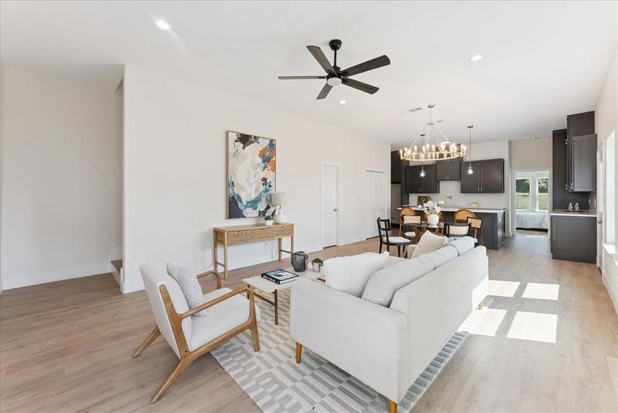 Living room featuring a chandelier, recessed lighting, light wood finished floors, and a ceiling fan