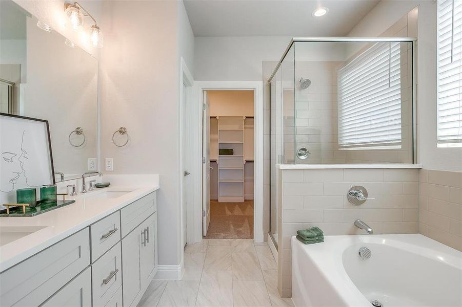 Bathroom featuring vanity and separate shower and tub