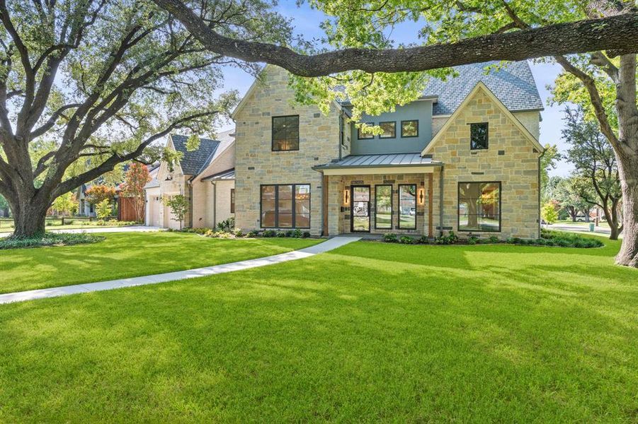 View of front of property with stone siding, a standing seam roof, and a front lawn View of front of property with stone siding, a standing seam roof, and a front lawn