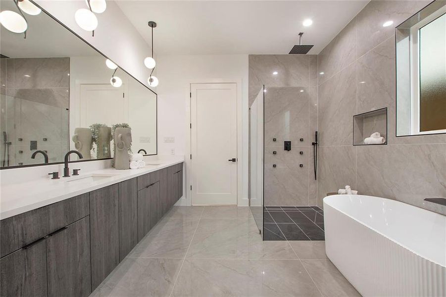 Bathroom with a tile shower, marble tiled floors, a freestanding bath, double vanity, and tile walls Bathroom with a tile shower, marble tiled floors, a freestanding bath, double vanity, and tile walls