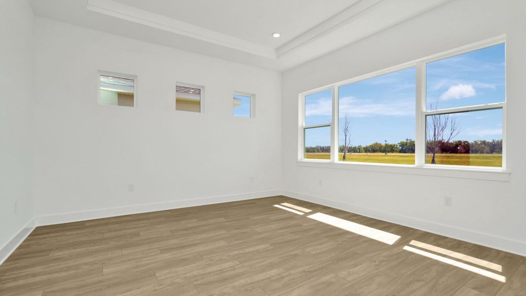 The Primary Bedroom of a DRB Homes Grand Hawk which is offered as a home plan at Serengeti in Spring Hill, FL.