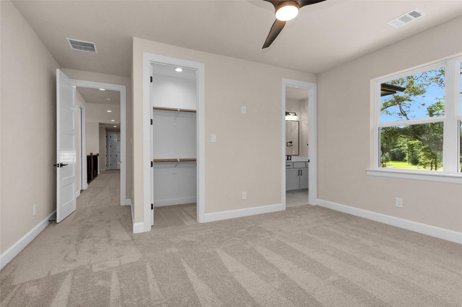 The walk-in closet features builtin shelving and ample hangingspace