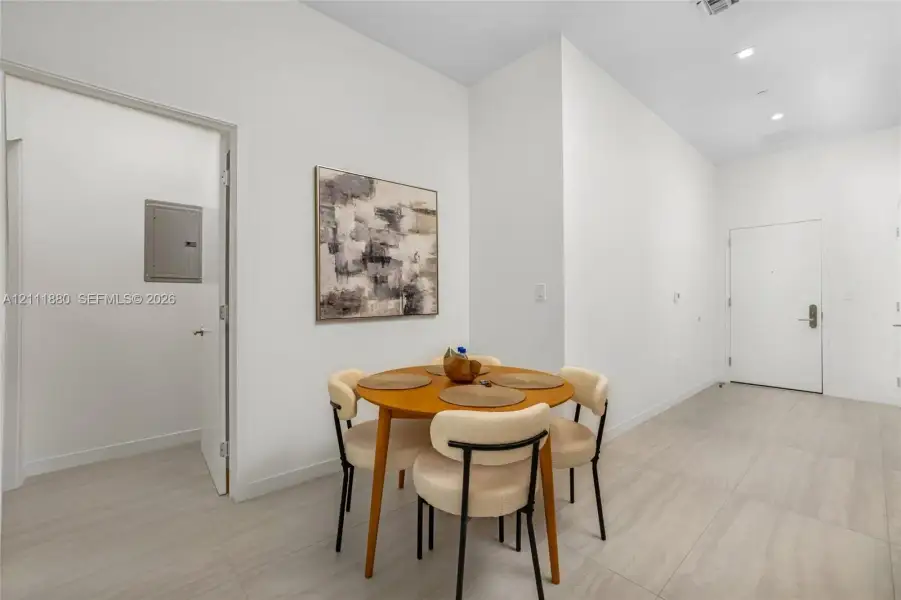 Interior space featuring high ceilings, neutral wall tones, large-format tile flooring, and recessed lighting